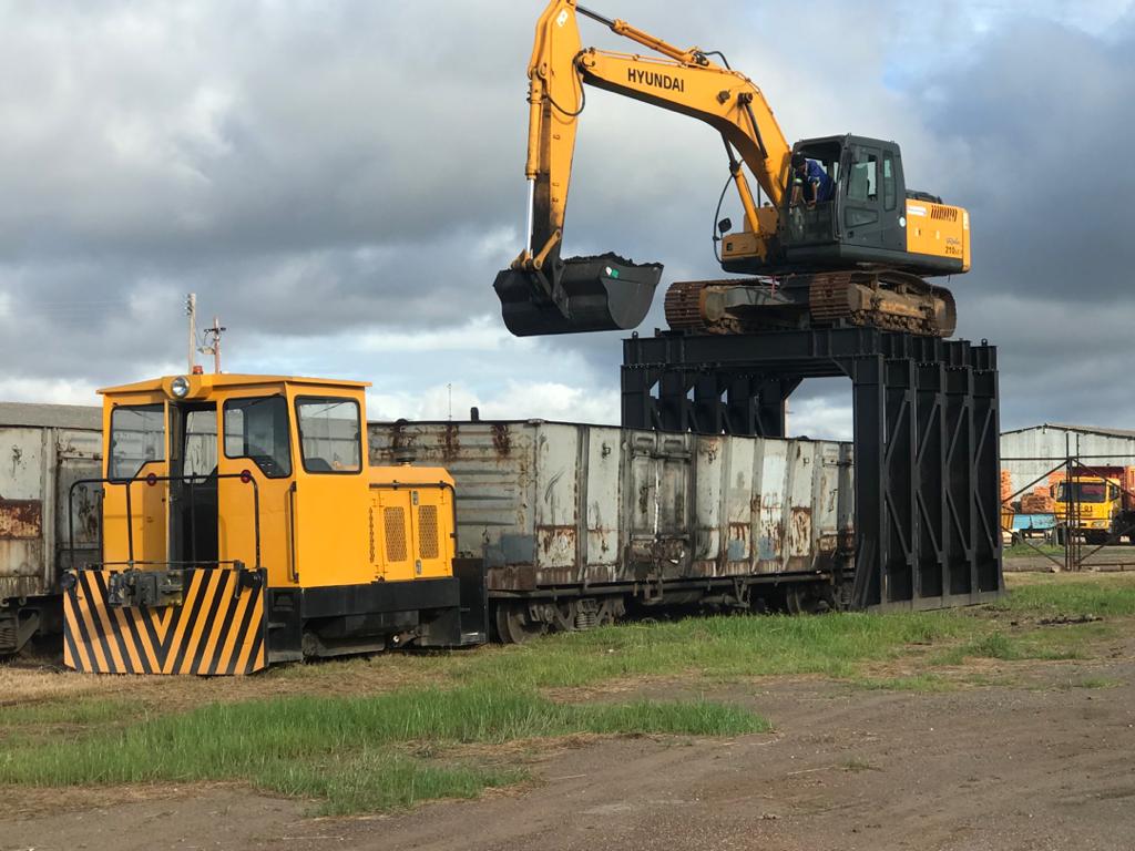 Excavator on the loading gantry filling wagons, shunter alongside